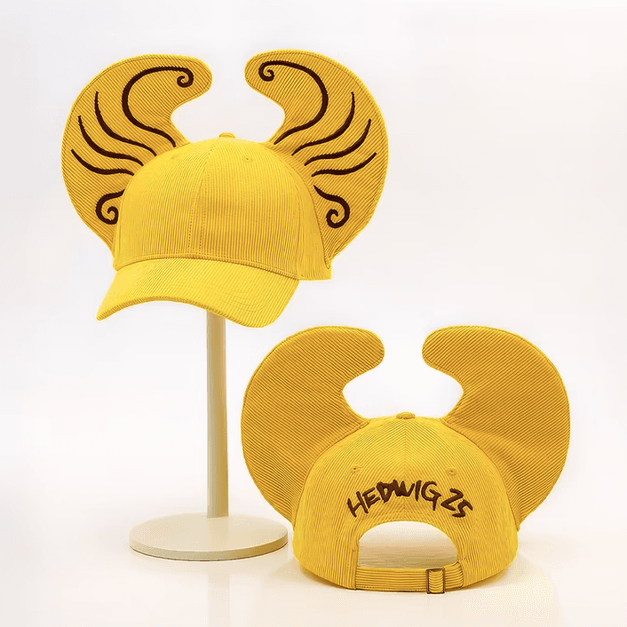 Yellow corduroy baseball cap with embroidered wings and "Hedwig 25" text, shown front and back.